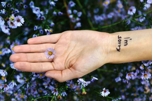 Hand of young woman with tattooed phrase — Stock Photo, Image