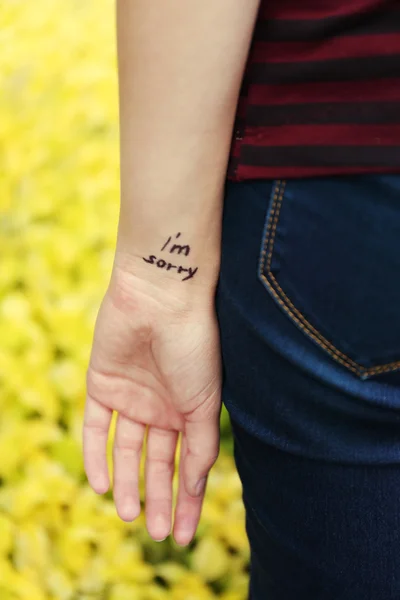 Mão de jovem com frase tatuada — Fotografia de Stock