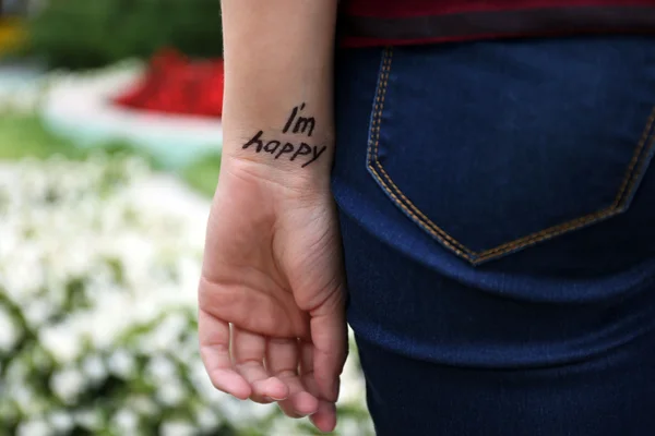 Hand of young woman with tattooed phrase — Stock Photo, Image