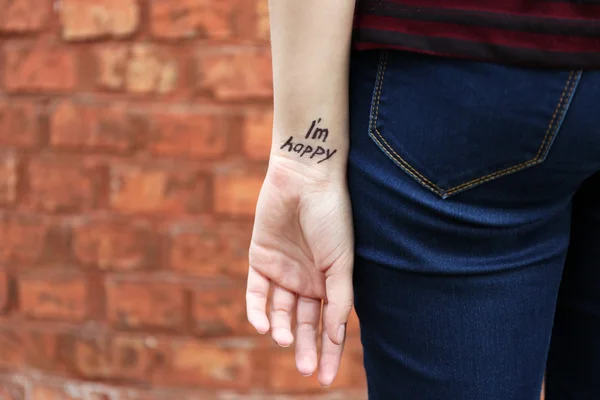 Рука молодої жінки з татуюванням фразою — стокове фото