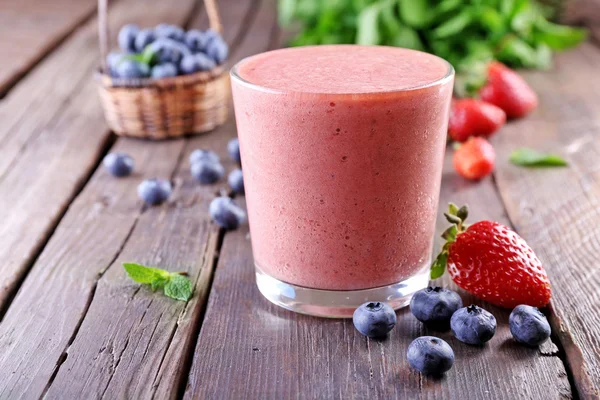 A glass of fresh cold smoothie with berries, on wooden background — Stock Photo, Image