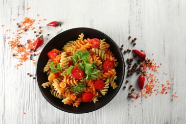 Üzerinde siyah kase lezzetli makarna yemek biber gri ahşap masa ile dekore edilmiştir.