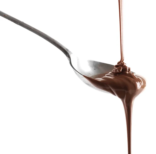 Melted milk chocolate pouring from a spoon, isolated on white — Stock Photo, Image