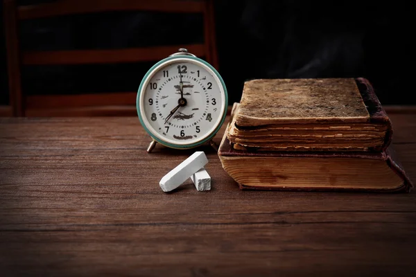 Books and clock on table — Stock Photo, Image