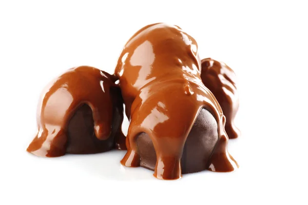 Chocolat versé sur bonbons isolés sur blanc — Photo