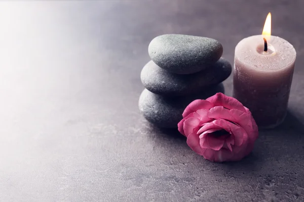 Aroma candle with pebbles and flower  on grey background — Stock Photo, Image