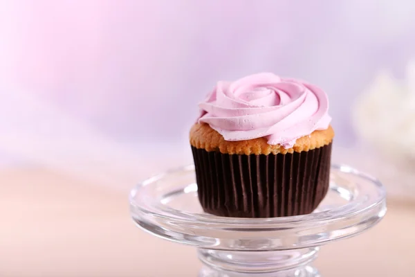 Tasty cupcake on stand, on light background — Stock Photo, Image