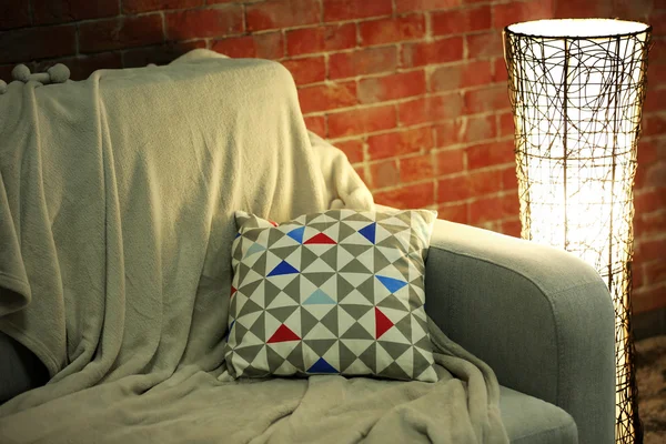 Зручний диван і сучасна лампа на фоні цегляної стіни — стокове фото