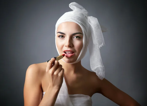 Frau mit Mullbinde mit Lippenstift — Stockfoto