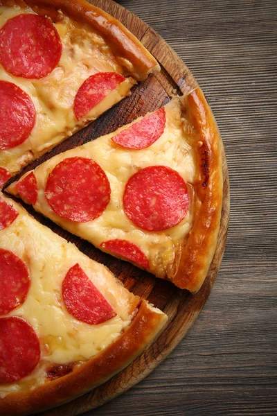 木製の背景にサラミとホットのおいしいピザ — ストック写真