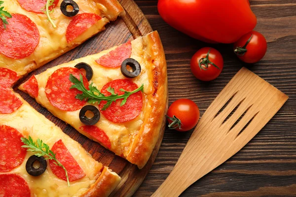 Hot νόστιμο πίτσα με σαλάμι και ελιές σε ξύλινα φόντο, κοντινό πλάνο — Φωτογραφία Αρχείου