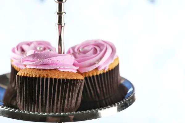 Cupcakes saborosos em stand, em fundo de cor — Fotografia de Stock