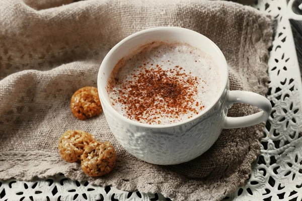 Чашка горячего какао с печеньем и орехами на ватной салфетке — стоковое фото
