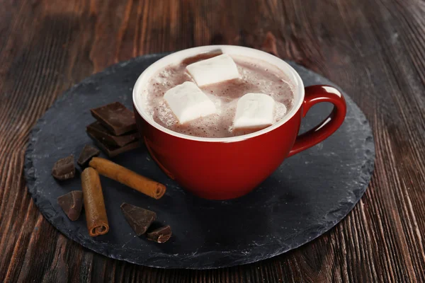 Tazza di cacao caldo con marshmallow, cannella e dolci su serviette blu, primo piano — Foto Stock