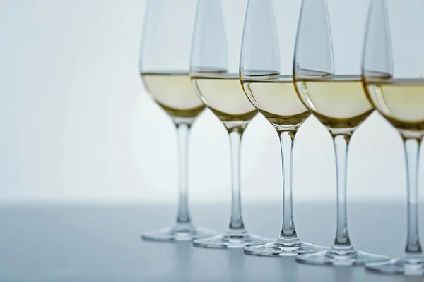 Bicchieri da vino con vino bianco su tavolo di legno su sfondo brillante — Foto Stock