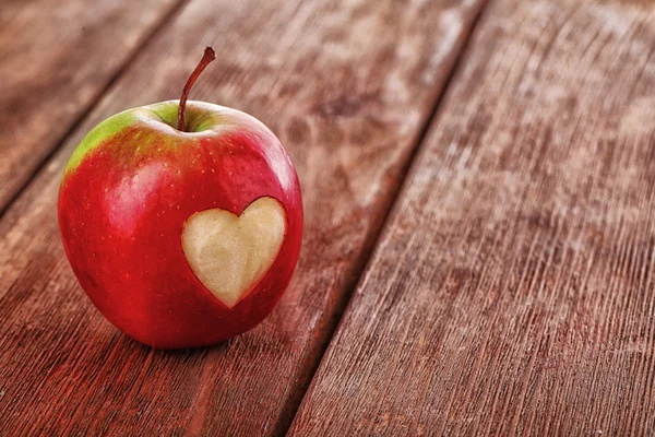 Manzana con corazón sobre mesa de madera —  Fotos de Stock