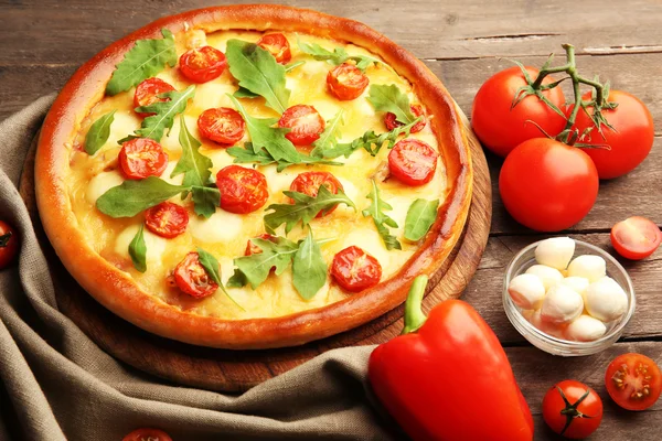 Pizza Margherita avec roquette et légumes sur table en bois — Photo