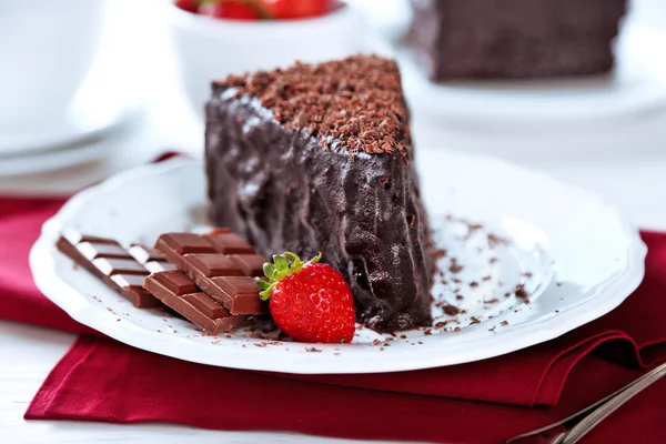 Choklad kaka med choklad grädde och färska jordgubbar på plattan, på ljus bakgrund — Stockfoto