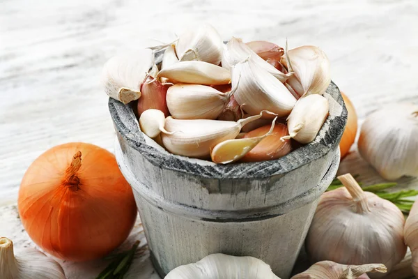 Samenstelling van knoflook, ui en rozemarijn op houten tafel — Stockfoto