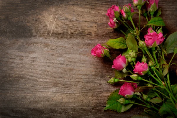 Hermoso ramo de rosas rosadas sobre fondo de madera, espacio para copiar — Foto de Stock