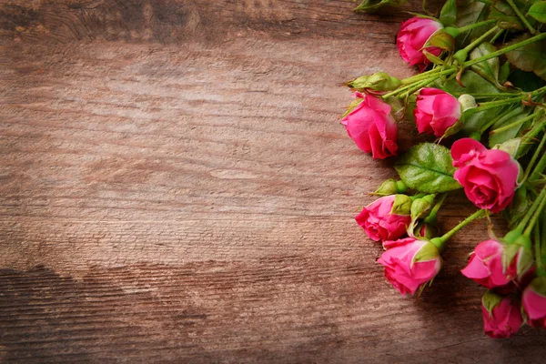 Hermoso ramo de rosas rosadas sobre fondo de madera, espacio para copiar — Foto de Stock