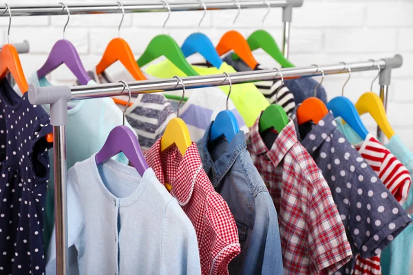 Kleding voor kinderen op hangers in een kamer — Stockfoto