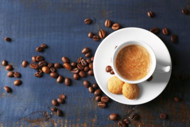 Ahşap masa arkasında bir fincan kahve.