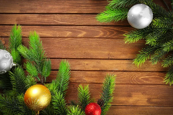 Fir kerstboom takken met speelgoed op houten tafel — Stockfoto