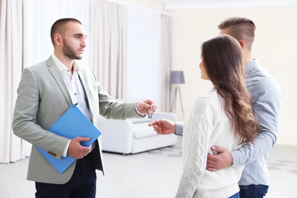 Estate agent giving keys to couple — Stock Photo, Image