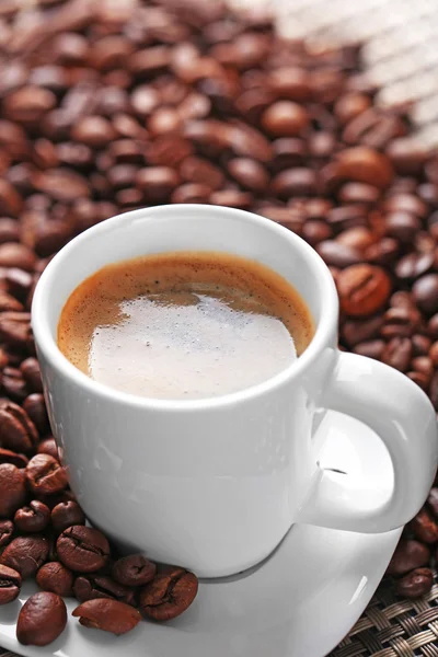Tasse de café et grains de café sur fond sombre — Photo