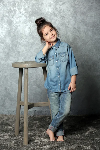 Портрет маленькой девочки моды на сером фоне стены — стоковое фото