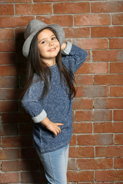 Retrato de pequena menina criança moda em tijolos parede fundo — Fotografia de Stock