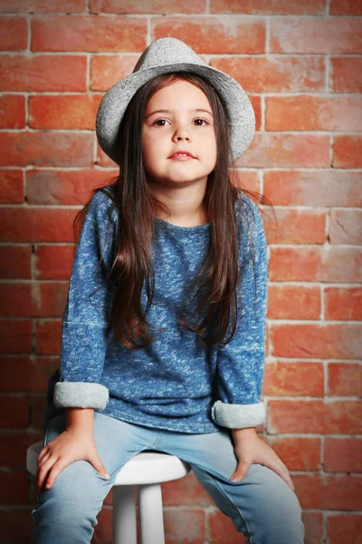 Портрет маленькой девочки моды на фоне кирпичной стены — стоковое фото