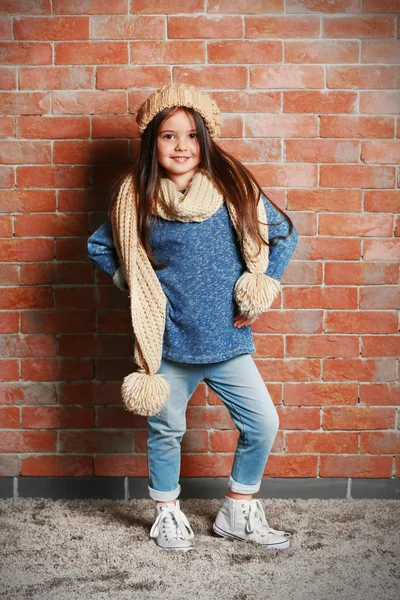 Portrait of little fashion kid girl on bricks wall background — Stock Photo, Image