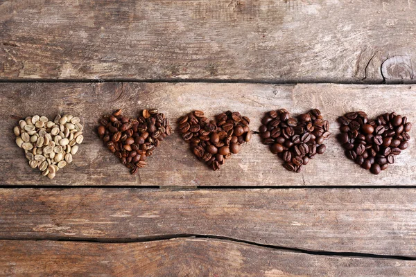 Sammlung von Kaffeebohnen auf altem Holztisch, Nahaufnahme — Stockfoto