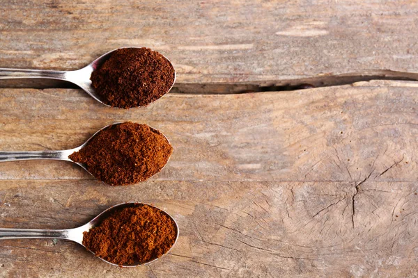 Spoons with coffee on wooden table, close up — Stock Photo, Image