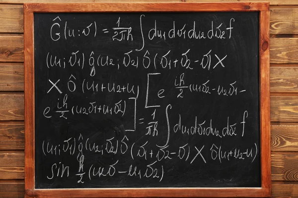 School blackboard with formulas on a brick wall — Stock Photo, Image
