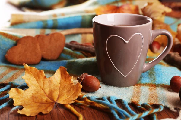 Tasse Tee mit Herbstdekor auf Holztisch. — Stockfoto