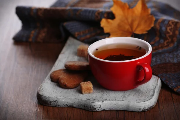 Taza de té con decoración otoñal sobre mesa de madera . — Foto de Stock
