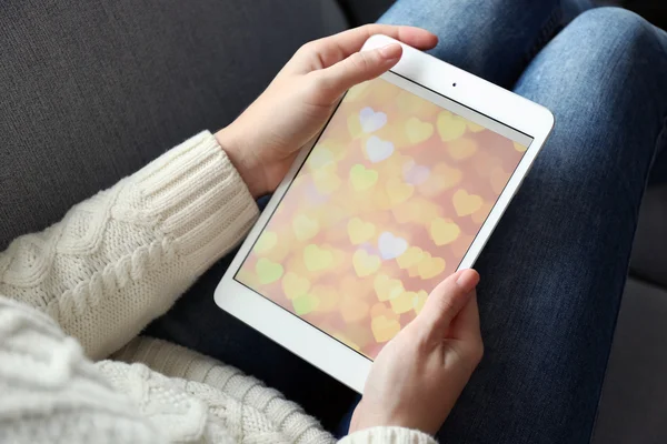 Female hand holding PC tablet on home interior background