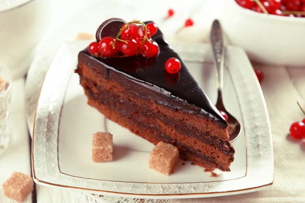 Bolo de chocolate saboroso com bagas na mesa de perto — Fotografia de Stock