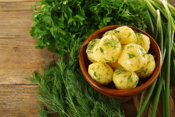 टेबलवर बाऊलमध्ये हिरव्यांसह उकळलेले बटाटे बंद — स्टॉक फोटो, इमेज