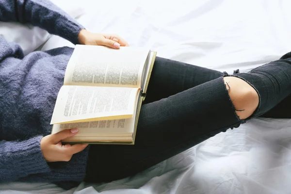 Frau in Jeans auf dem Bett — Stockfoto