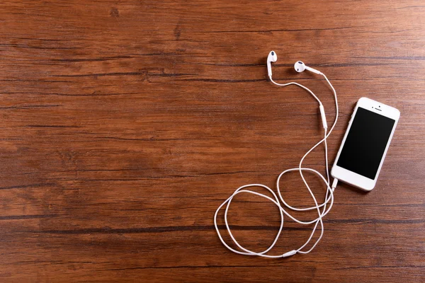 Celular branco com fones de ouvido — Fotografia de Stock