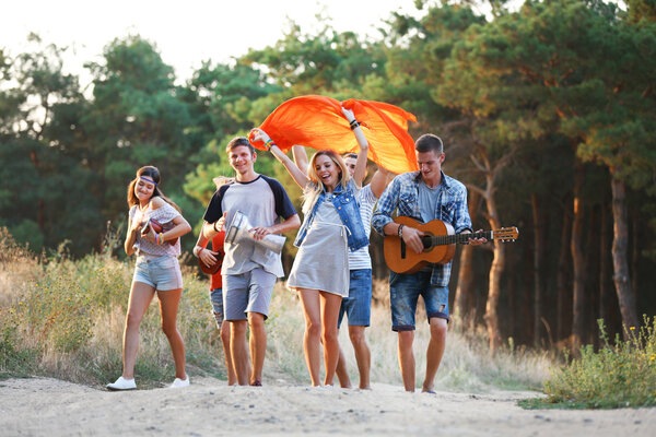 Cheerful friends walking on footpath from the forest