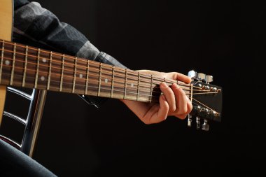 Müzisyen siyah arka plan üzerine gitar çalıyor, yakın çekim