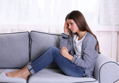 Kanepede oturan üzgün kız 