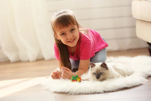 Cute girl playing with kitten — Stock Photo, Image