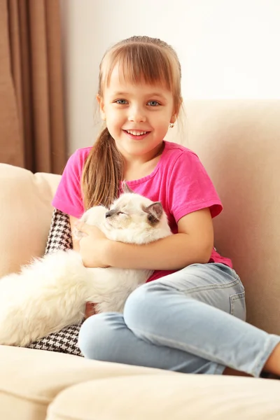 Girl with kitten on sofa — Stock Photo, Image
