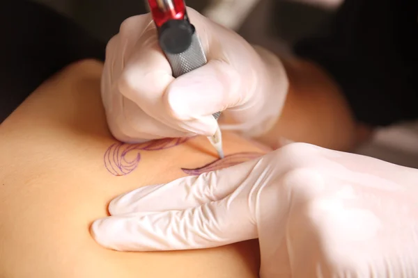 Hands in medicine gloves make tattoo — Stock Photo, Image